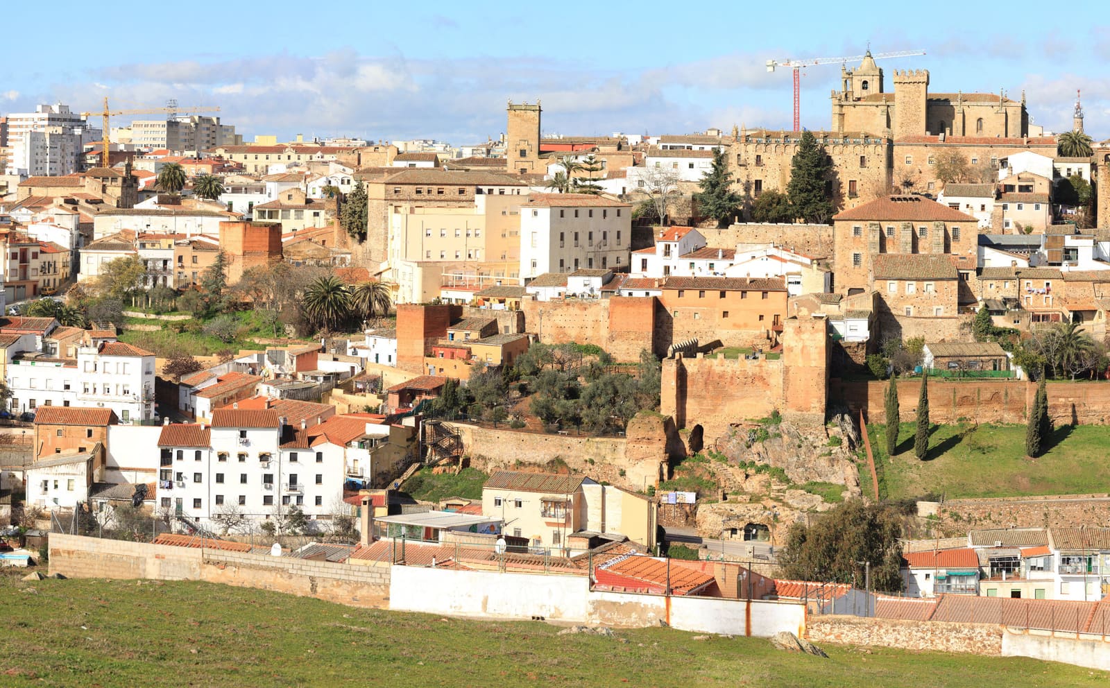 Vista da Ciudad Monumental de Cáceres ao entardecer, com as torres medievais de pedra douradas pela luz do sol