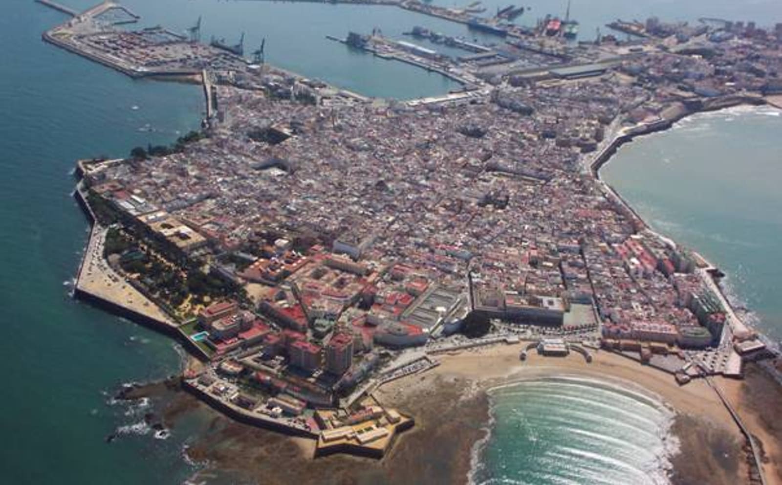 O pôr do sol visto da Playa de La Caleta, entre os castelos de Santa Catalina e San Sebastián, em Cádiz