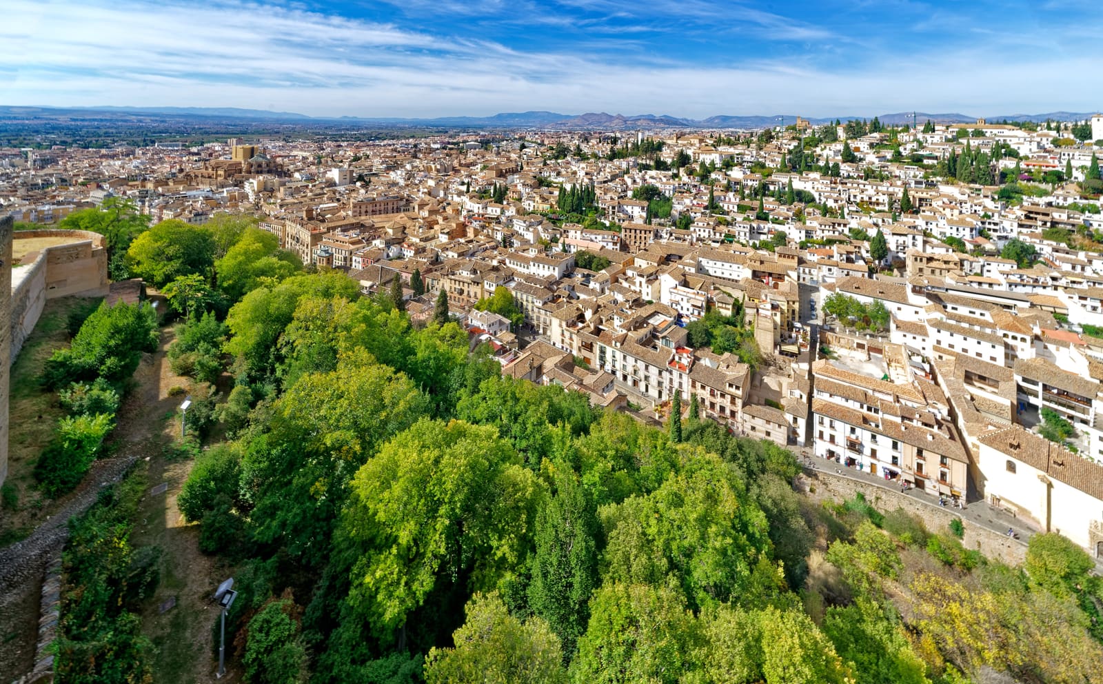 Casario branco do Albaicín, em Granada, visto do alto sobre a encosta arborizada da Alhambra