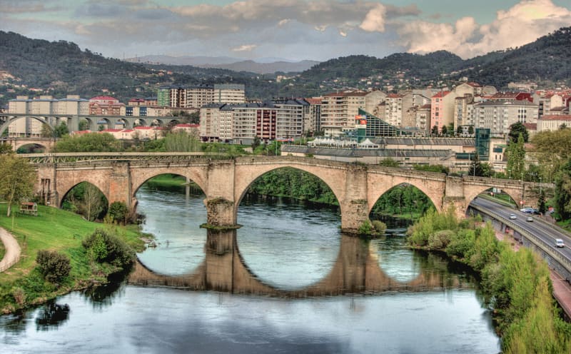 Vista da Ponte Romana sobre o rio Minho em Ourense, com o casco velho e a catedral ao fundo, envoltos em névoa