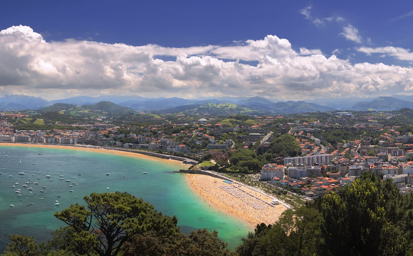 Vista da baía de La Concha em San Sebastián a partir do Monte Igueldo ao entardecer, com a praia em forma de concha e o Casco Antiguo ao fundo