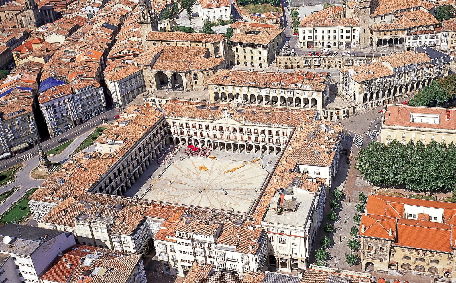 Vista aérea do casco medieval em forma de amêndoa de Vitoria-Gasteiz, com a Catedral de Santa María a dominar o horizonte e os telhados da cidade basca ao entardecer